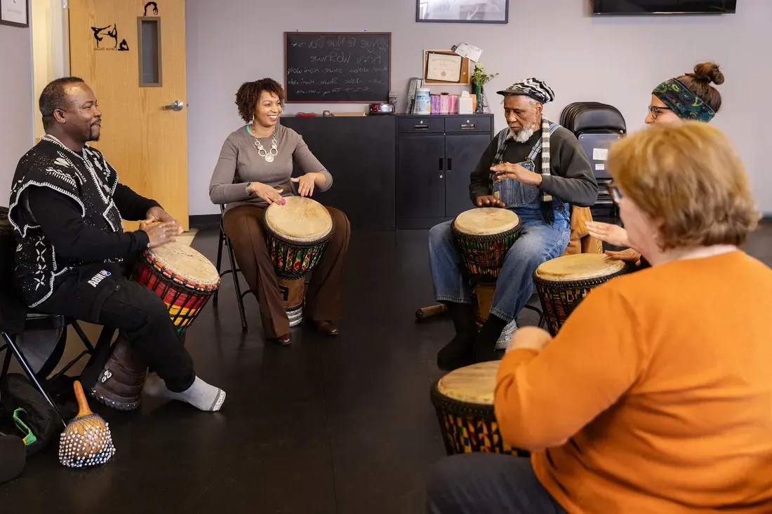 Tanisha Jackson playing bongos with people at the Community Folk Art Center.